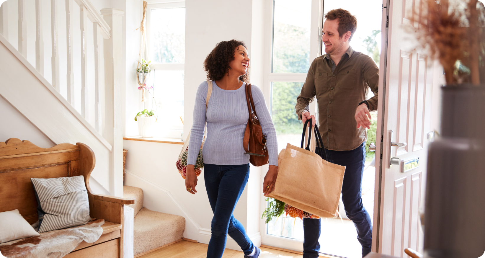 A man and a woman return home with shopping