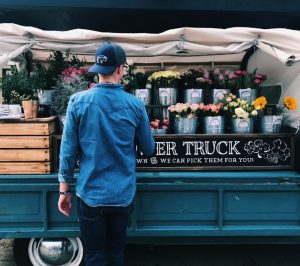 Man picking flowers from the back of a truck