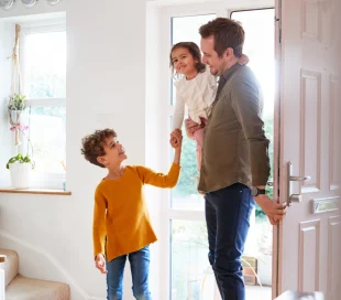 A father and his two children enter the flat
