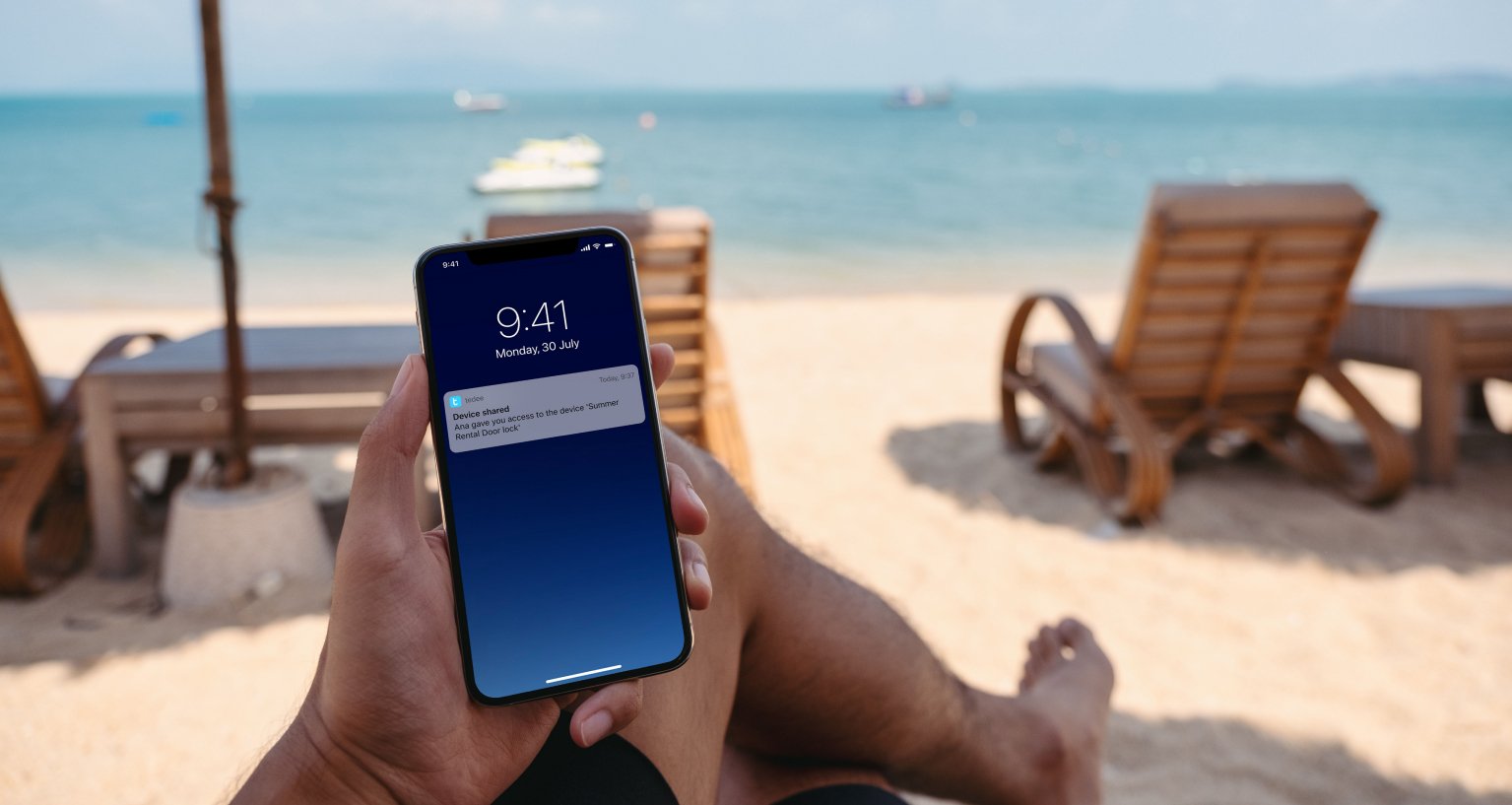 Man op strand ontvangt bericht op smartphone