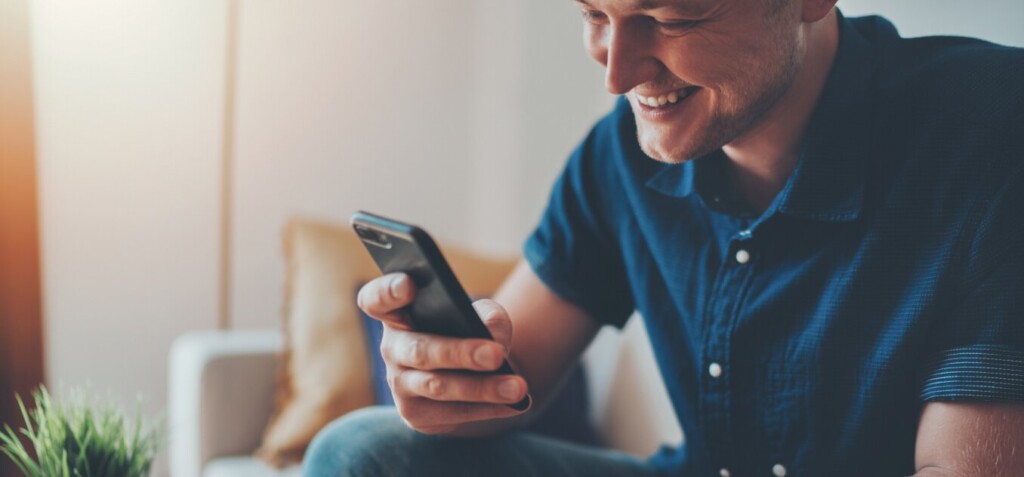 happy man uses a smartphone