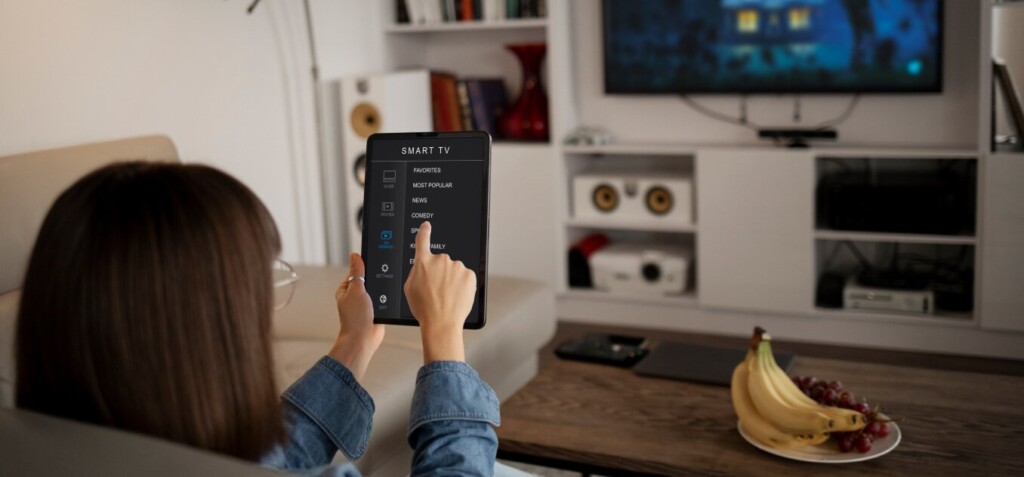 a woman sitting on the sofa controls the smart tv