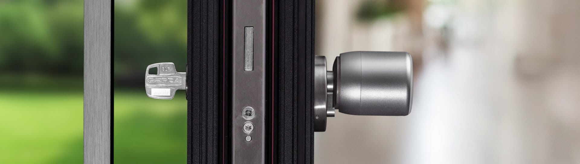 The image provides a cross-sectional view of a door. To the left, outside the building, lies a lawn dotted with trees. On the right, within the apartment, the door is equipped with a handle and a smart lock positioned at the height of the keyhole. Only a pull handle and a key are visible on the door's exterior side.